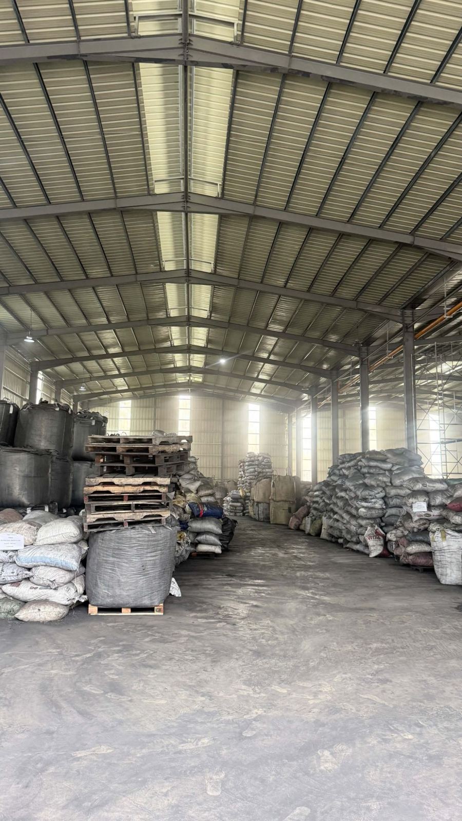Warehouse interior with bulk bags and stacked charcoal sacks